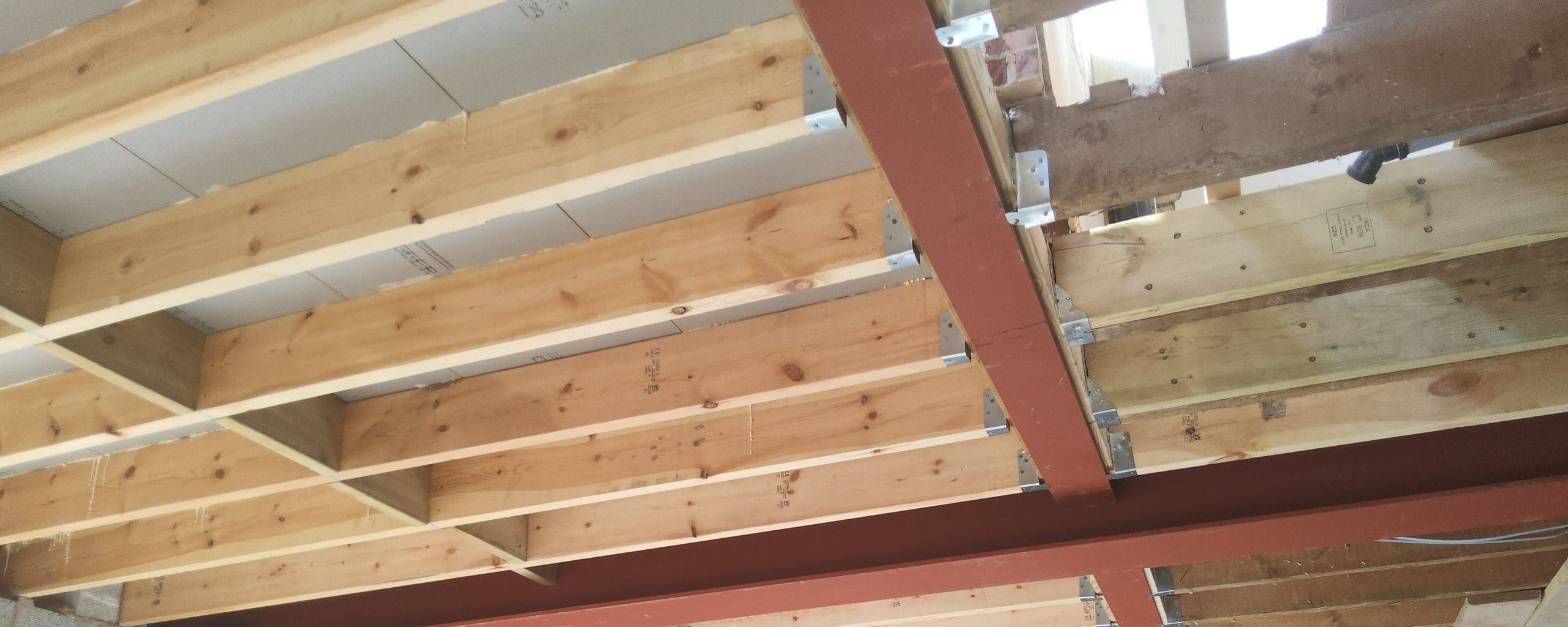 Steel beam supporting floor timbers as part of a structural wall-removal project